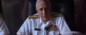 Movie still from “Crimson Tide” (1995), directed by Tony Scott – An older man in a white uniform sitting in a chair; Close Up shot, Low angle
