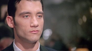 Movie still from “Croupier” (1998), directed by Mike Hodges – A person wearing a suit and tie; Close Up shot, High angle