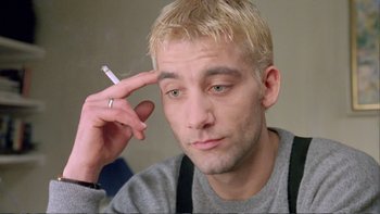 Movie still from “Croupier” (1998), directed by Mike Hodges – A person holding a cigarette in his hand; Close Up shot, High angle