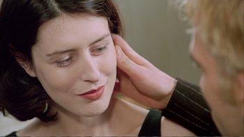 Movie still from “Croupier” (1998), directed by Mike Hodges – A woman is getting her ears cleaned by a person; Close Up shot, Over the shoulder angle