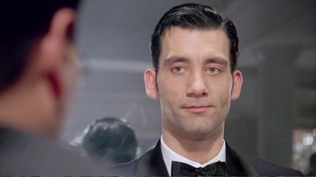 Movie still from “Croupier” (1998), directed by Mike Hodges – A person wearing a tuxedo; Close Up shot, Over the shoulder angle
