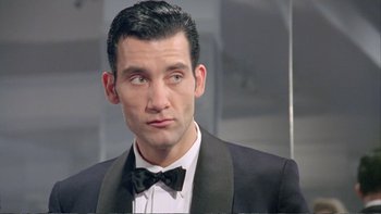 Movie still from “Croupier” (1998), directed by Mike Hodges – A person wearing a suit and bow tie; Close Up shot, Low angle