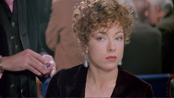 Movie still from “Croupier” (1998), directed by Mike Hodges – A person with curly brown hair; Close Up shot, Over the shoulder angle