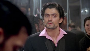 Movie still from “Croupier” (1998), directed by Mike Hodges – A person wearing a suit and pink shirt; Close Up shot, Over the shoulder angle