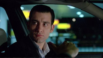 Movie still from “Croupier” (1998), directed by Mike Hodges – A person sitting in a car at night; Close Up shot, Low angle