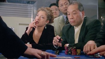Movie still from “Croupier” (1998), directed by Mike Hodges – A group of people sitting at a table playing poker; Medium shot, High angle