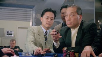 Movie still from “Croupier” (1998), directed by Mike Hodges – A group of men sitting at a table playing a game; Close Up shot, High angle