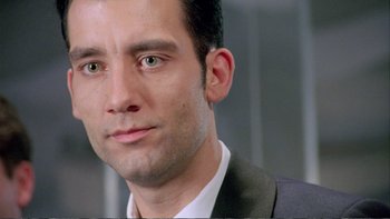 Movie still from “Croupier” (1998), directed by Mike Hodges – A person wearing a suit and tie; Close Up shot, Over the shoulder angle