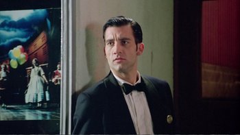 Movie still from “Croupier” (1998), directed by Mike Hodges – A man in a suit and bow tie; Close Up shot, Low angle