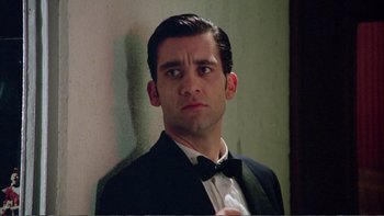 Movie still from “Croupier” (1998), directed by Mike Hodges – A person wearing a suit and tie; Close Up shot, Low angle