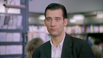 Movie still from “Croupier” (1998), directed by Mike Hodges – A man in a black suit and a white shirt; Close Up shot, Low angle