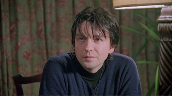 Movie still from “Croupier” (1998), directed by Mike Hodges – A person sitting in a room; Close Up shot, Over the shoulder angle