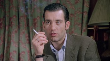 Movie still from “Croupier” (1998), directed by Mike Hodges – A person smoking a cigarette; Close Up shot, Low angle