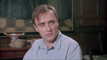 Movie still from “Croupier” (1998), directed by Mike Hodges – A person sitting in a room; Close Up shot, Low angle