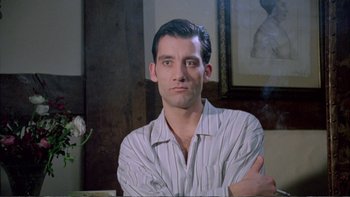 Movie still from “Croupier” (1998), directed by Mike Hodges – A person sitting in a room; Close Up shot, Low angle