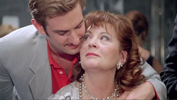 Movie still from “Croupier” (1998), directed by Mike Hodges – A man and a woman are kissing each other; Close Up shot, Low angle