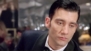 Movie still from “Croupier” (1998), directed by Mike Hodges – A man in a suit and tie; Close Up shot, Low angle
