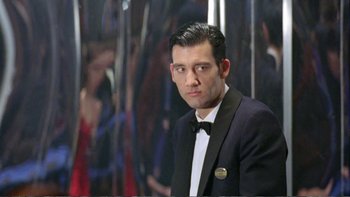 Movie still from “Croupier” (1998), directed by Mike Hodges – A man in a tuxedo standing in front of a mirror; Medium shot, Low angle