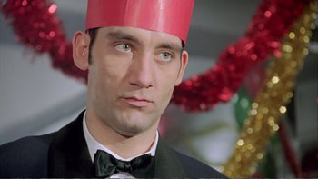 Movie still from “Croupier” (1998), directed by Mike Hodges – A person wearing a paper hat; Close Up shot, Low angle