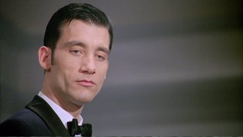 Movie still from “Croupier” (1998), directed by Mike Hodges – A person wearing a suit and bow tie; Close Up shot, Low angle