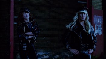 Movie still from “Cruising” (1980), directed by William Friedkin – A couple of people that are standing up in a room; Medium shot, Low angle