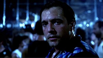 Movie still from “Cruising” (1980), directed by William Friedkin – A person wearing a blue and white striped shirt; Close Up shot, Low angle