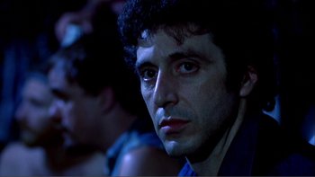Movie still from “Cruising” (1980), directed by William Friedkin – A person wearing a blue shirt; Close Up shot, Low angle