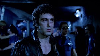 Movie still from “Cruising” (1980), directed by William Friedkin – A man in a black leather jacket looking to his left; Close Up shot, Low angle