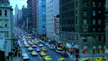 Movie still from “Cruising” (1980), directed by William Friedkin – A street filled with lots of yellow taxis driving down it; Extreme Wide shot, High angle