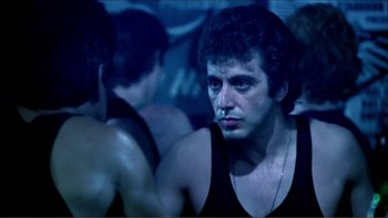Movie still from “Cruising” (1980), directed by William Friedkin – A person wearing a tank top; Close Up shot, Over the shoulder angle