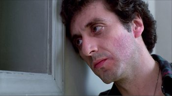 Movie still from “Cruising” (1980), directed by William Friedkin – A person with his head on a wall; Close Up shot, Low angle