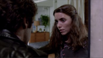 Movie still from “Cruising” (1980), directed by William Friedkin – A young woman with long brown hair is looking at a young man; Close Up shot, Over the shoulder angle