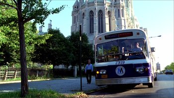 Movie still from “Cruising” (1980), directed by William Friedkin – A man standing next to a bus on a city street; Extreme Wide shot, Low angle
