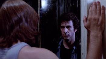 Movie still from “Cruising” (1980), directed by William Friedkin – A man looking at himself in the mirror; Close Up shot, Over the shoulder angle