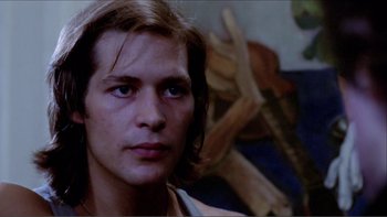 Movie still from “Cruising” (1980), directed by William Friedkin – A person with long brown hair; Close Up shot, Low angle