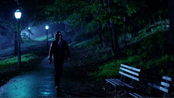 Movie still from “Cruising” (1980), directed by William Friedkin – A man walking down a path in the dark; Wide shot, High angle