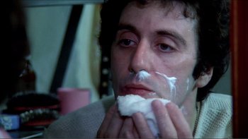 Movie still from “Cruising” (1980), directed by William Friedkin – A man is shaving his face in a bathroom; Close Up shot, Low angle