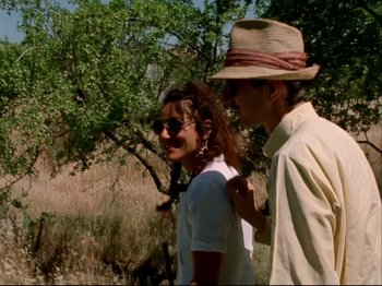 A man and a woman are walking in the grass