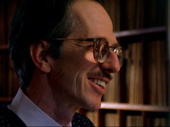 Movie still from “Crumb” (1994), directed by Terry Zwigoff – A person wearing glasses and a suit; Close Up shot, Low angle