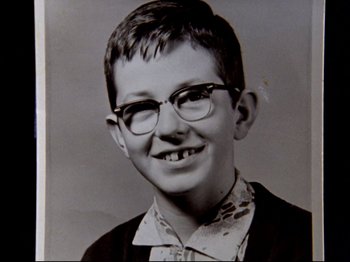 Movie still from “Crumb” (1994), directed by Terry Zwigoff – An old black and white photo of a boy wearing glasses; Close Up shot, Low angle