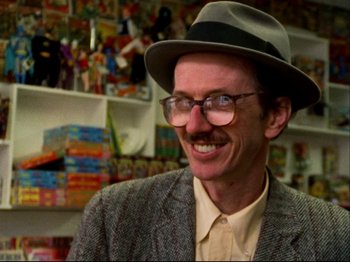 Movie still from “Crumb” (1994), directed by Terry Zwigoff – A man with a mustache wearing a hat and glasses; Close Up shot, Low angle