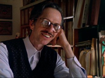 Movie still from “Crumb” (1994), directed by Terry Zwigoff – A man with a beard and glasses smiling for the camera; Close Up shot, Low angle
