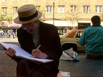 Movie still from “Crumb” (1994), directed by Terry Zwigoff – A man in a straw hat writing in a notebook; Medium shot, Low angle