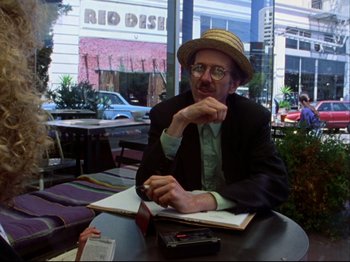 Movie still from “Crumb” (1994), directed by Terry Zwigoff – A man sitting at a table in a restaurant; Medium shot, Over the shoulder angle