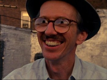 Movie still from “Crumb” (1994), directed by Terry Zwigoff – A person wearing glasses and a hat; Close Up shot, Low angle