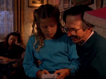 Movie still from “Crumb” (1994), directed by Terry Zwigoff – An older man and a young girl looking at an electronic device; Medium shot, Over the shoulder angle