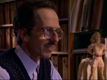 Movie still from “Crumb” (1994), directed by Terry Zwigoff – A man in a suit and tie wearing glasses and a tie; Close Up shot, Low angle