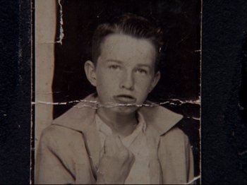 Movie still from “Crumb” (1994), directed by Terry Zwigoff – An old black and white photo of a young man; Extreme Close Up shot, Overhead angle