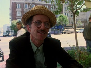 Movie still from “Crumb” (1994), directed by Terry Zwigoff – An older man wearing a straw hat sitting on a park bench; Close Up shot, Low angle