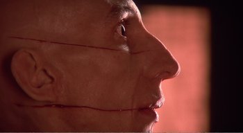 Movie still from “Cube” (1997), directed by Vincenzo Natali – View of the face of a person; Extreme Close Up shot, Low angle